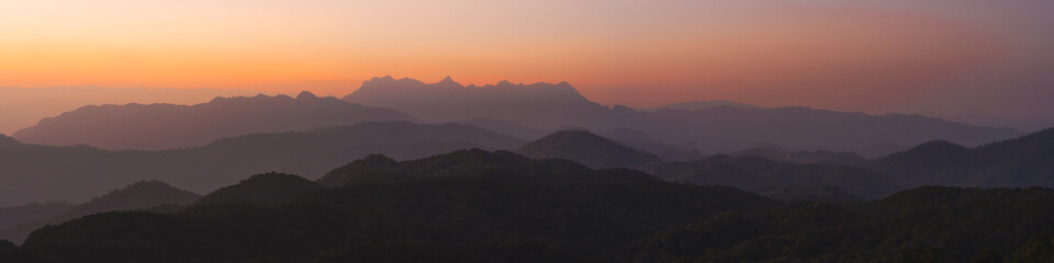 nature traveling with panorama orange sky and layer of mountain with sunrise background