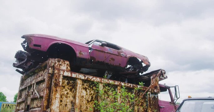 1971 Fast back mustang sitting on top of a dump truck exposed to the elements and rusting away.