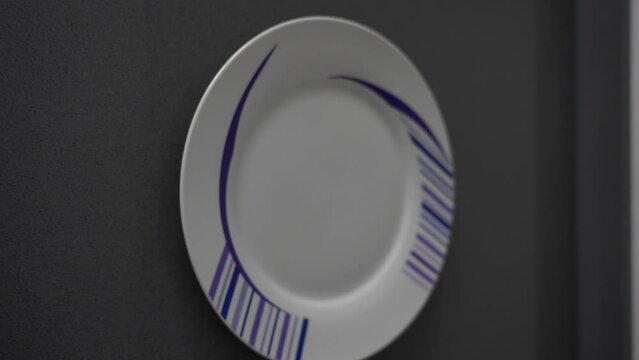 Pullback from clean white plate with blue linework pattern on grey countertop