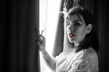 Black and white comic style image of a beautiful and sensual woman smoking in a nightgown next to...