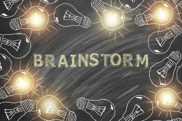 Shining light bulbs with lettering BRAINSTORM hand drawn in chalk on blackboard. Concept of brainstorming. Idea concept.