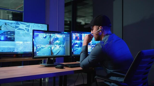 Security officer with headset in system control room answer phone call