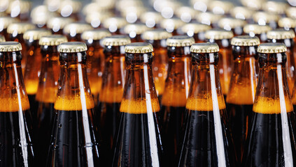 Brown glass beer bottles on conveyor belt Automated brewery industry manufacturing with sunlight