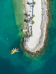 Aerial drone shot of Kasjuni beach near Split with brightly coloured kayaks and a swimmer