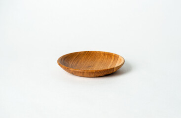 Wooden bowl isolated on white background. The bowl is round and has a smooth surface. The concept of simplicity and natural beauty. The wooden bowl is unadorned and uncluttered.