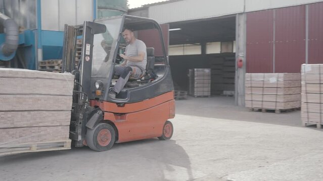 Factory worker driving forklift in factory
