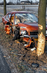 Fototapeta na wymiar Crashed car against tree Netherlands. Nineties. Accident. Damaged car. Carwreck.