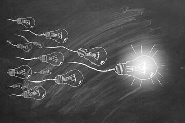 Light bulbs that look like sperm seeds hand drawn on a blackboard. Best idea concept.