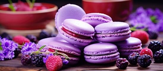 Obraz na płótnie Canvas A stack of handmade violet macaroons topped with assorted fruits resting on a simple wooden table. The macaroons have a smooth outer shell and a soft, chewy interior, creating a visually appealing