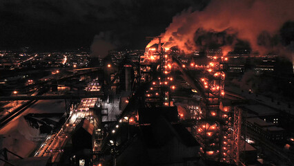 Night top view of the blast furnace of a metallurgical plant. Bright lights, smoke and smog of an industrial area