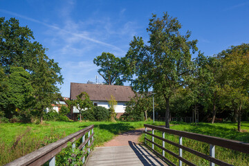 Fußgängerbrücke mit Weg in einer Grünanlage und Wohnhäusern, Wunstorf, Niedersachsen,...