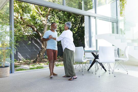 Senior biracial couple in casual attire enjoys a conversation outdoors - Powered by Adobe