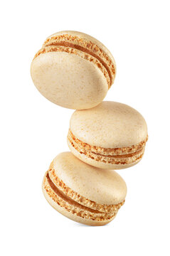Three coconut yellow macarons isolated. Sweet levitated meringue-based confection. Transparent PNG image.