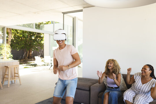 Young Asian man enjoys a virtual reality experience, wearing a VR headset