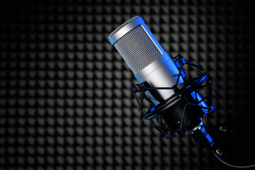 Microphone in the studio with black noise cancelling panel. Professional sound recording equipment.