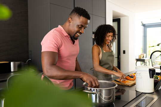 Biracial African American couple prepare a meal together in a modern kitchen at home