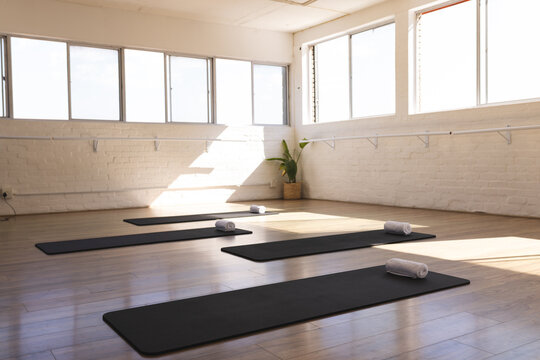 A serene yoga studio awaits practitioners, bathed in natural light, with copy space