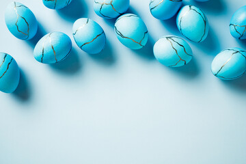 Blue Easter eggs with stone or marble effect on light blue background. Happy Easter concept. Top view, flat lay.