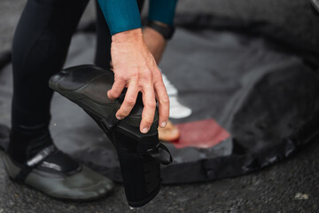 Surfer Preparing Wetsuit Boots on Shore