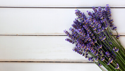 Fresh flowers of lavender bouquet, top view on white wooden background with copy space; close up