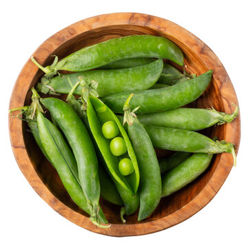Green pea pods in wooden bowl isolated on white. Top view.