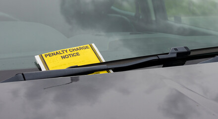 Penalty charge notice parking fine attached to car windscreen