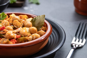Close up. Ropa vieja, typical Canarian dish of chickpeas stew on earthenware casserole on dark base.