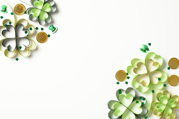 Paper cut clover leaves with gold coins and confetti on white background. Spring decorations for...