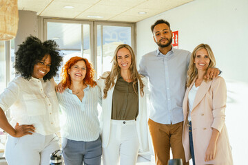 Group of diverse business people smiling while standing together in the office.