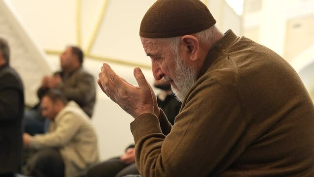  Old Muslim man with a prayer cap praying to Allah at Mosque in Ramadan month