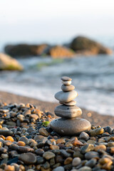 A pebble tower balances harmonious stones. Vertical photo