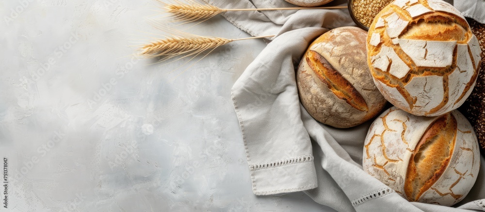 Poster a variety of multigrain rustic bread is arranged neatly on a table, placed on top of kitchen towels 
