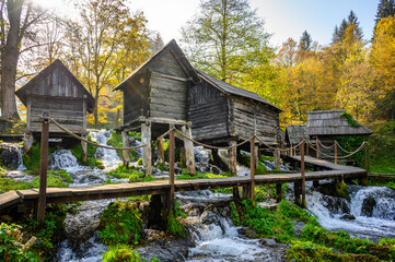Old small wooden water mills called Mlincici built on Pliva lake near Jajce, Bosnia and Herzegovina. - obrazy, fototapety, plakaty
