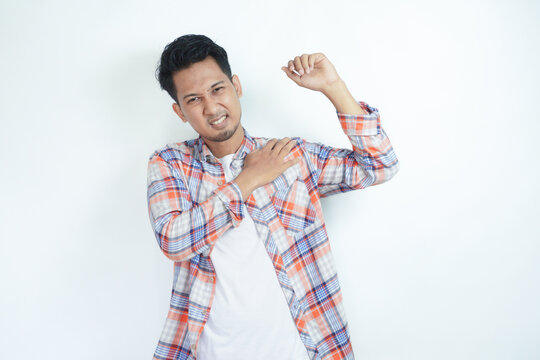 Adult Asian man touching his left shoulder with pain expression