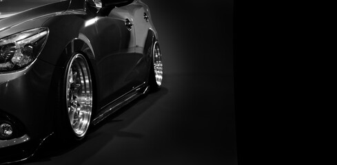 Front headlights of black modify car on black background	