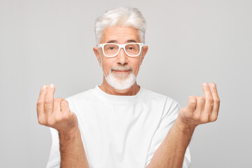 Elderly man showing hearts or money sign with finger on white background
