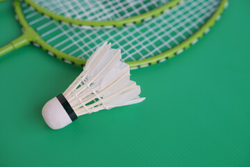 Shuttlecock and rackets. Badminton sport equipments on green background. Concept, sport, exercise,...