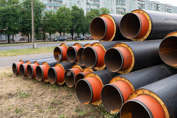 Steel pipe with heat insulation. New black insulated steel pipes at municipal construction site...