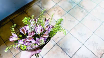 Bouquet of garden flowers against tiled floor. Defocused. Film grain texture. Soft focus. Blur