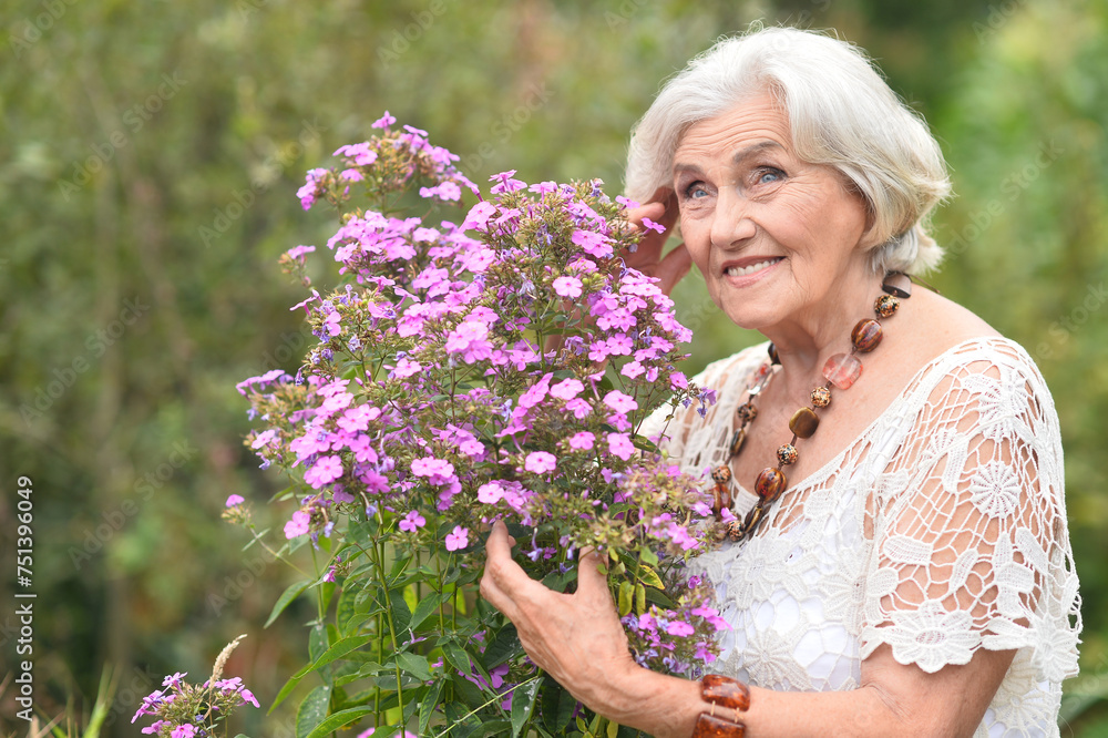 Wall mural Portrait of happy senior woman posing at forest