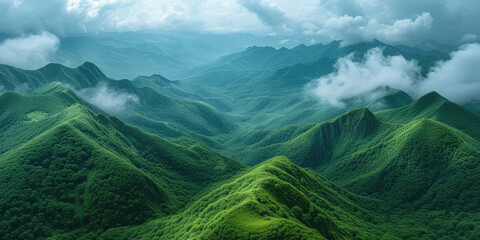 Lush green mountain ranges shrouded in mist under a soft, glowing sky.