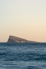 Benidorm Island at sunset. A small island in the Mediterranean Sea illuminated by the sun at dusk.