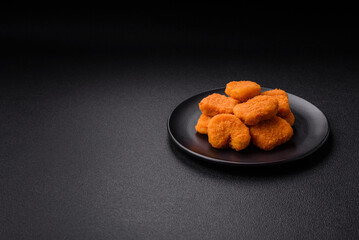 Delicious fresh crispy chicken nuggets on a dark concrete background