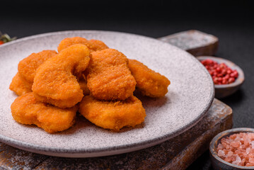 Delicious fresh crispy chicken nuggets on a dark concrete background