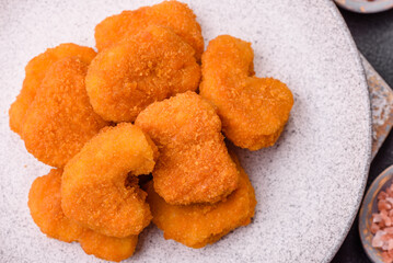 Delicious fresh crispy chicken nuggets on a dark concrete background