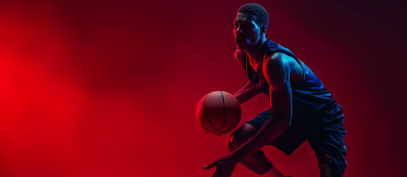 Portrait of afro american male basketball player with a ball over black background.