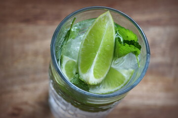 Mojito cocktail with lime and mint in highball glass on a table