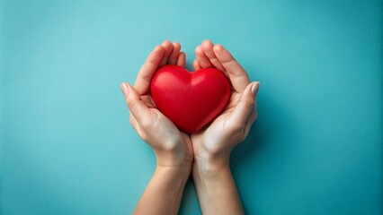 Fototapeta premium Female hands hold a red heart on a colorful background. The concept of love and health.