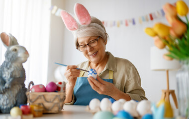 Senior woman painting eggs
