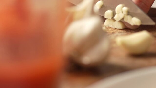 Dolly shot of Diced garlic on a chopping board. Fried Assassin's Spaghetti Cooking Step. Close-up, shallow dof.